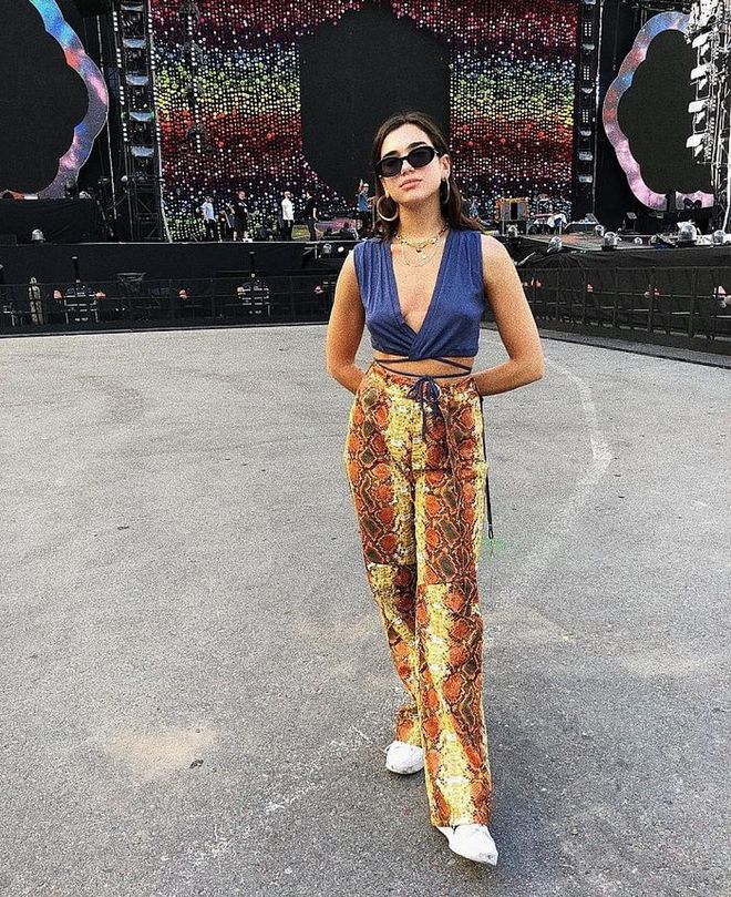Dua drops by Coldplay's concert in Beunos Aires, Argentina wearing this navy Marieyat wrap top, I.AM.GIA pants, Roberi &amp; Fraud Black Betty Sunglasses, and Adidas Originals Superstar Bold Sneakers. This necklace ensembles sees pieces from 
Joomi Lim, David Yurman and Amulette de Cartier. Photo: Instagram