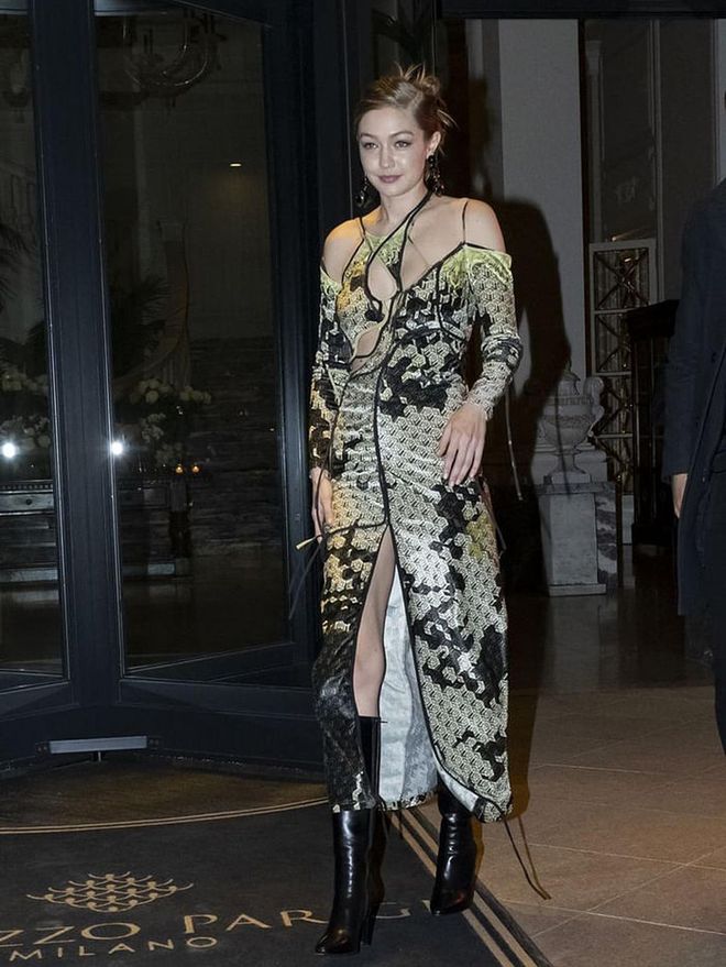 While in Milan, Gigi stepped out in a cut-out dress by Ottolinger, which she paired with black patent boots. 