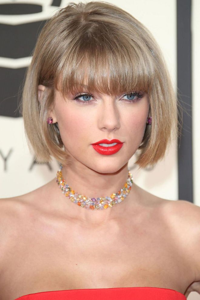 Swift's signature red lip got an edgy upgrade this year—veering into electric peach territory.

