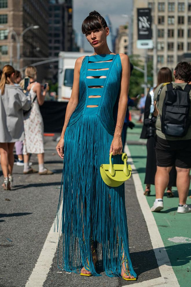 NEW YORK, NEW YORK - SEPTEMBER 13: Katya Tolstova is seen wearing a turquoise long dress with tassels, paired with a neon green handbag and open toe heels in the same shade. (Photo by David Dee Delgado/Getty Images)