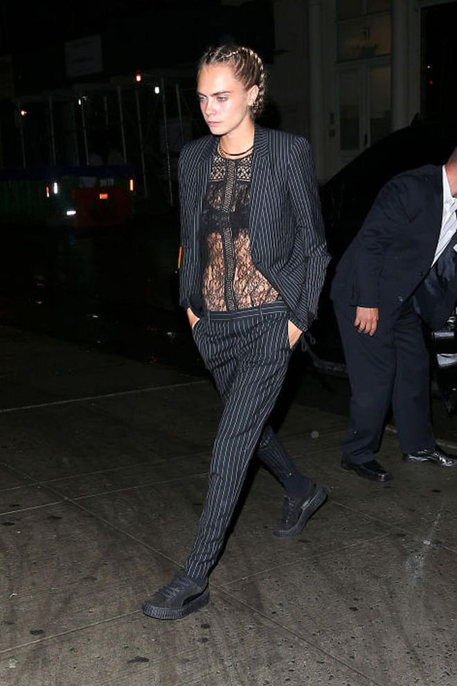 Cara Delevingne attends a party at Bar Belle Reve with her 'Suicide Squad' cast member Margot Robbie in New York City wearing a striped pantsuit and sheer lace top. Photo: Getty