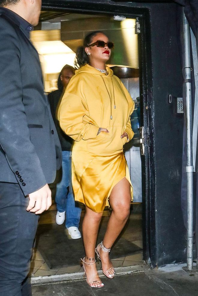The multi-hyphenate was spotted in L.A. wearing a mustard yellow Fenty hoodie dress and satin skirt, blinged out accessories, as well as strappy heeled sandals.