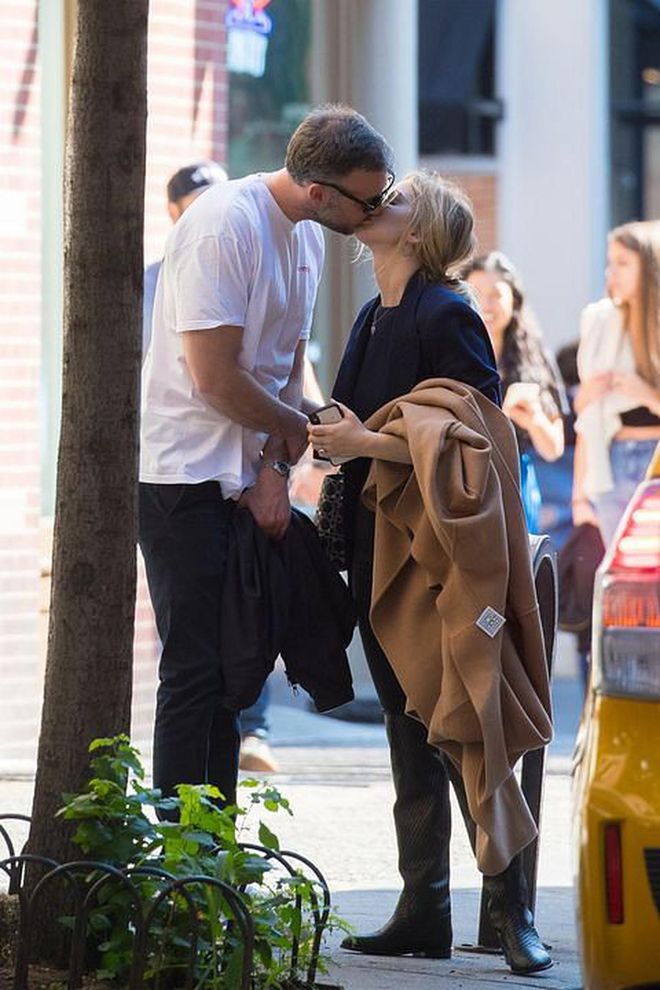 Cooke Maroney and Jennifer Lawrence kiss on a sidewalk in New York City.