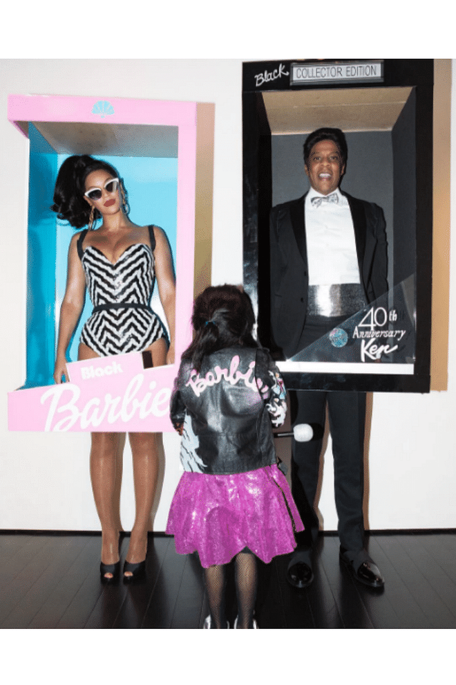The family coordinated costumes for a second time as Black Barbie and Ken dolls. 