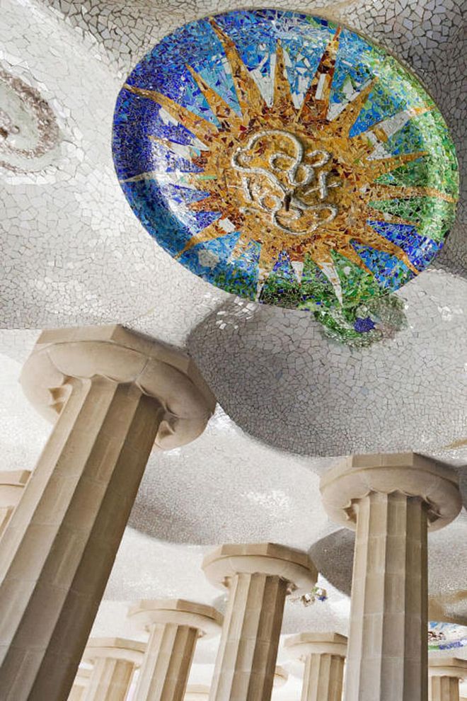 Designed to be the market for the community, the open-air pavilion at Park Güell is supported by nearly 100 doric columns and decorated with mosaic medallions.