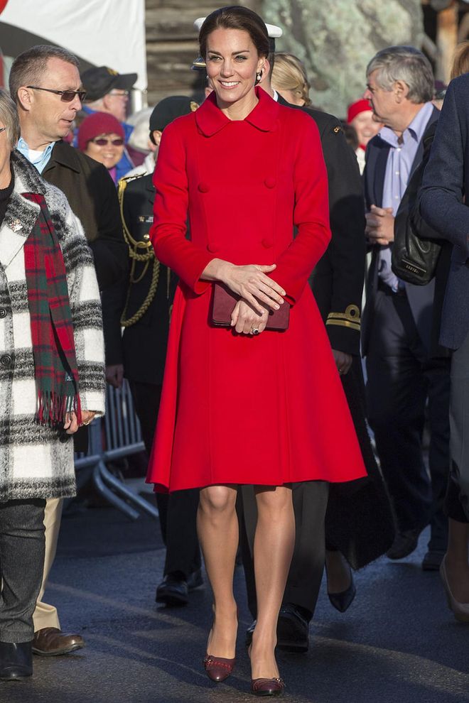 In a bright red CH Carolina Herrera coat, plum clutch and maroon pointed-toe pumps while visiting the MacBride Museum in Whitehorse, Canada. Photo: Getty
