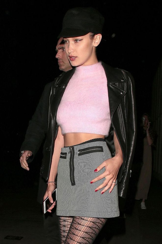 Bella Hadid is very Liv Tyler in 'Empire Records' in an A-line mini skirt and pink sweater, layered with a leather moto. It's a party look for a girl who is well beyond the LBD. Photo: Getty 
