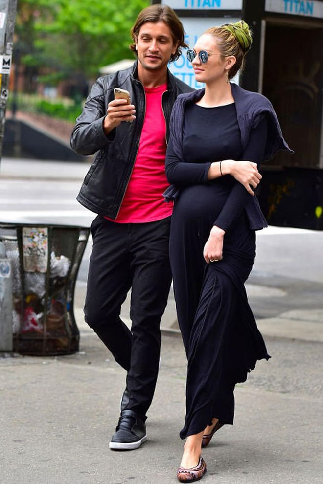 Pictured with her fiancé Hermann Nicoli, the Victoria's Secret angel combined a long black dress with ballet flats and a green scarf in her hair. Photo: Getty
