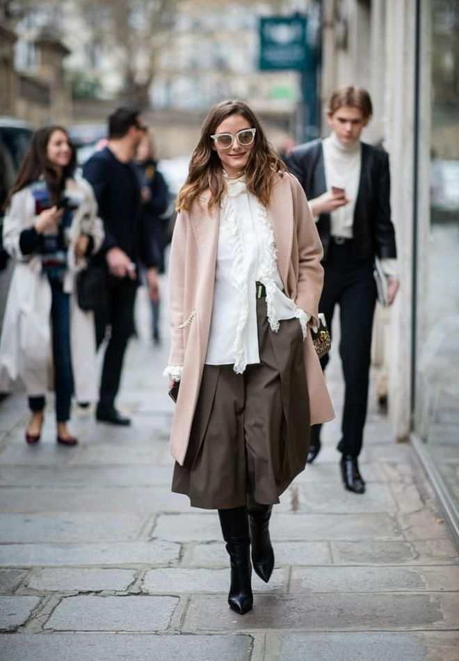 Layering is key to staying cozy yet chic during the fall months. Transition your knee-length skirt into the colder months by tucking your favorite tall boots underneath.

Photo: Christina Vierig / Getty