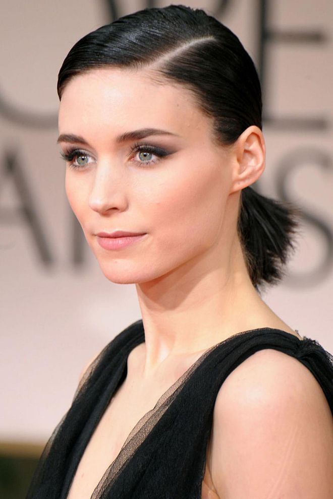 Actress Rooney Mara burst onto the scene in 2011's Girl With The Dragon Tattoo. But it was her press tour looks—full of graphic shapes, punk influences, and edgy sex appeal—that solidified Mara as a force in beauty and fashion. Here, she slicked her jet-black hair into a sculptural ponytail while taking a softer approach with a bit of black eyeshadow. 
