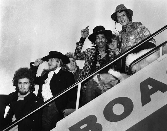 The rockstar and his band wave goodbye at London Airport, alongside assorted members of The 