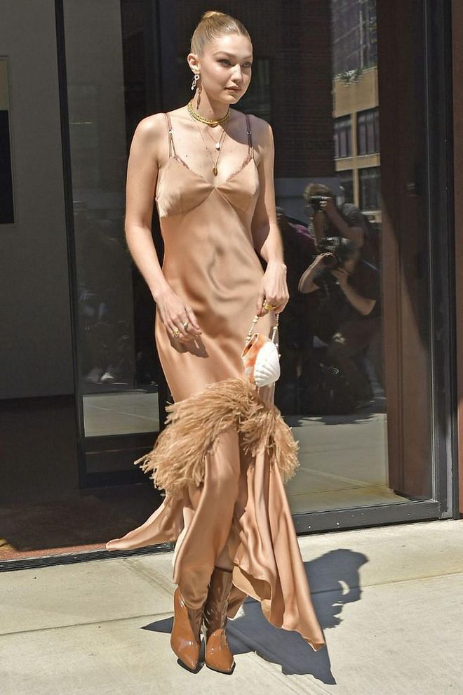 The model attended the launch of Michael Kors' Wonderlust perfume in a champagne fringe slip dress from the brand, tan boots and a WALD Berlin shell-shaped handbag. She also accessorised with shell earrings, layered gold necklaces and rings.