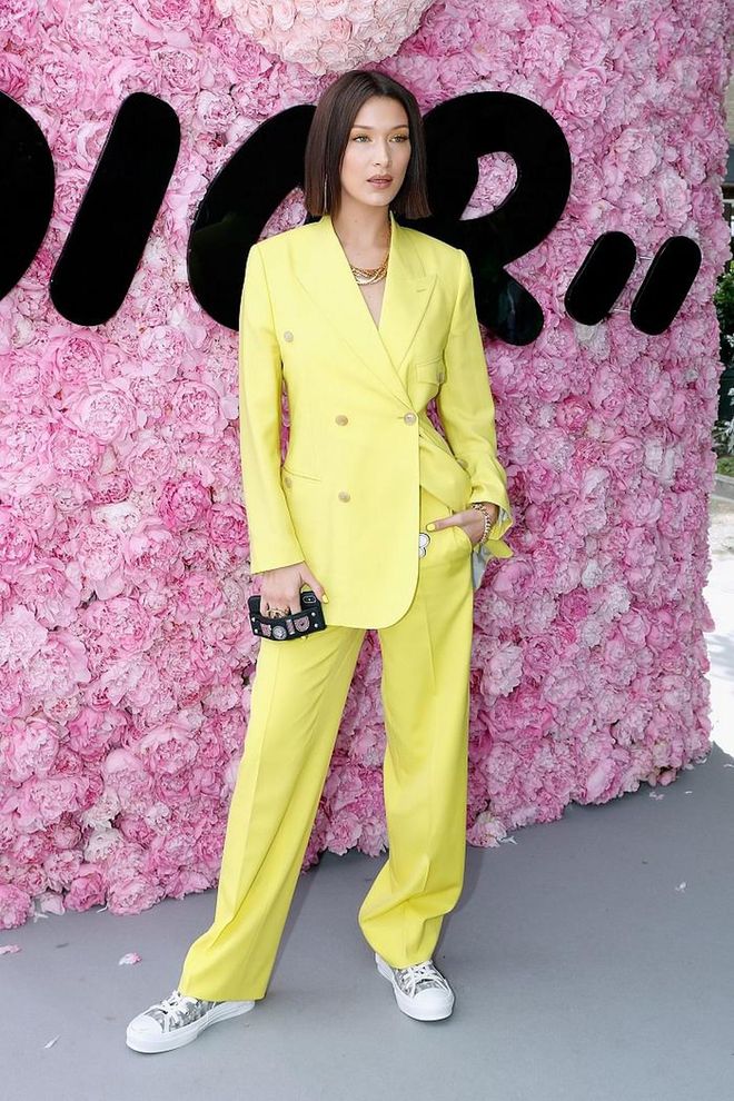 Attending the Dior Homme Menswear Spring/Summer 2019 show dressed in a neon yellow Dior double-breasted suit high-cut sneakers covered in the Dior monogram. 