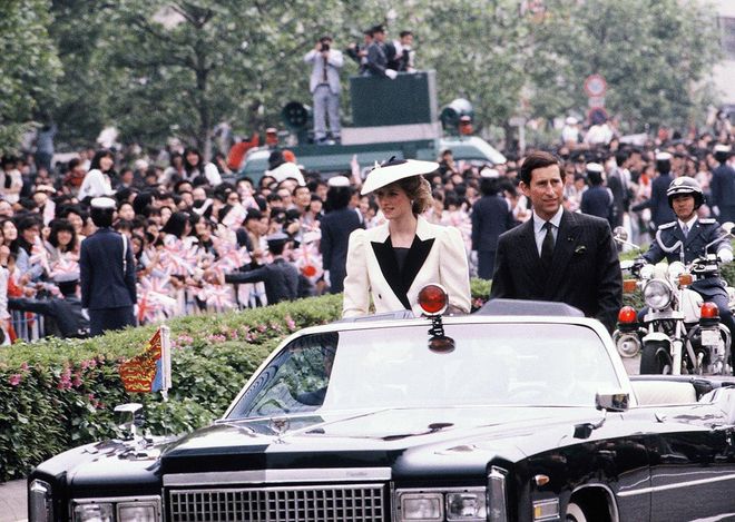 In a black and white suit and hat while riding through a royal welcoming parade with Prince Charles in Tokyo, Japan. Photo: Getty