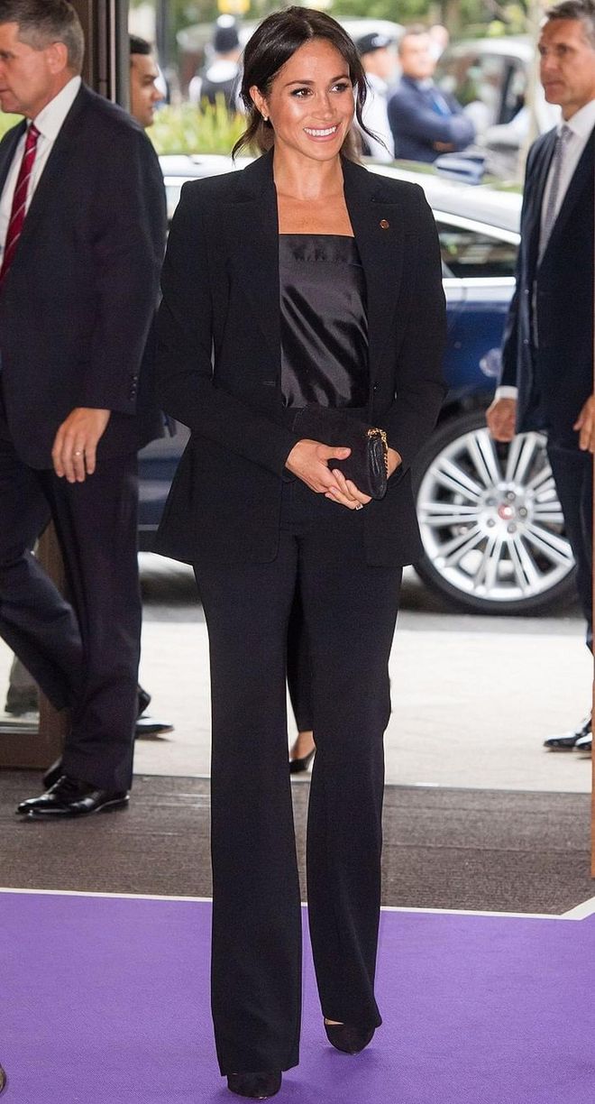 The Duchess stayed consistent with her last look, rocking another black outfit. This time it's a power suit by Altuzarra with a Deitas Coco Shantung camisole underneath. We're loving the flattering boot-cut of  her bottoms, with classic black pumps to elongate her legs further. She accessorized simply with a Stella McCartney clutch. Photo: Getty 