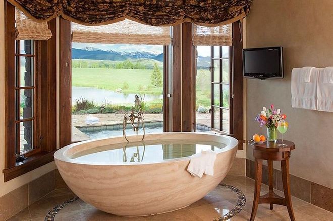 Luxury lodge Phillips Ridge overlooks the Jackson Hole valley which sits in between two mountain ranges in Wyoming. In the lodge, there's a bath tub which looks out onto the 100 acres of lush, largely untouched land.