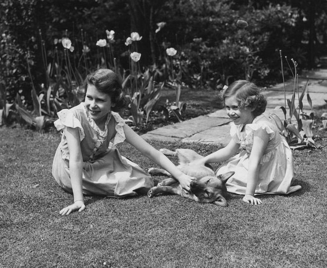 Another sweet moment with a family pet! Margaret and Elizabeth look delighted as they play with their corgi at the Royal Lodge in Windsor. In 1936, Elizabeth and Margaret had two corgis named Dookie and Jane.
Photo: Getty 