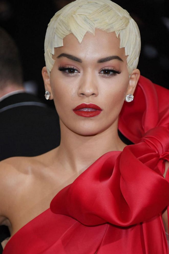 Ora's usual loose waves gets transformed into blonde panels plastered on like a sleek protective helmet.  She also complements her scarlet gown with matching matte red lips, and a light swipe of red eye shadow looking like a woman in command (Photo: Getty)