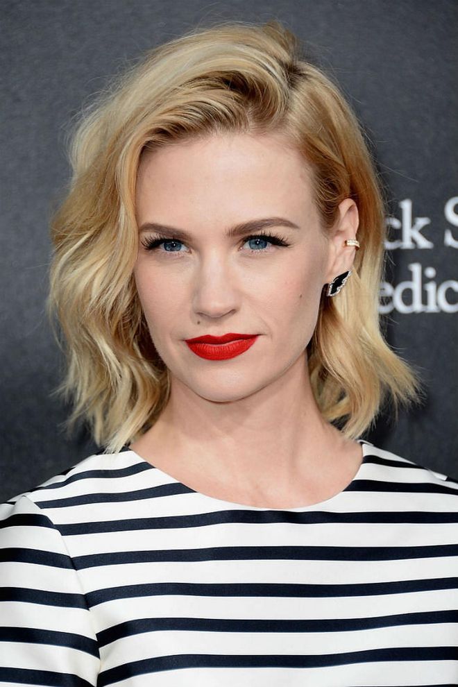 January Jones channels French girl vibes with casual waves flicked over the crown, red lips, and stripes.