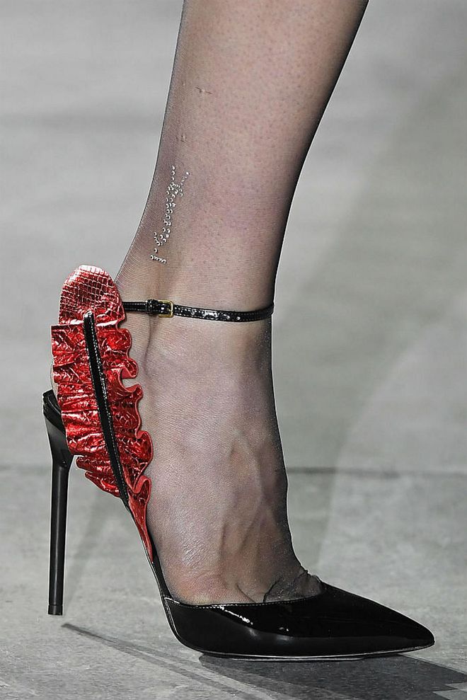 Seen in: Paris Fashion Week SS17 // Jet-black pointed toe stilettos with super thin heels and ankle straps are an ultra-chic addition to any wardrobe. Anthony Vacarello's adorning of a classic silhouette with a metallic blood-red exotic skin ruffle adds the right amount of sexiness to complete the design with a bang.  (Photo: Getty)