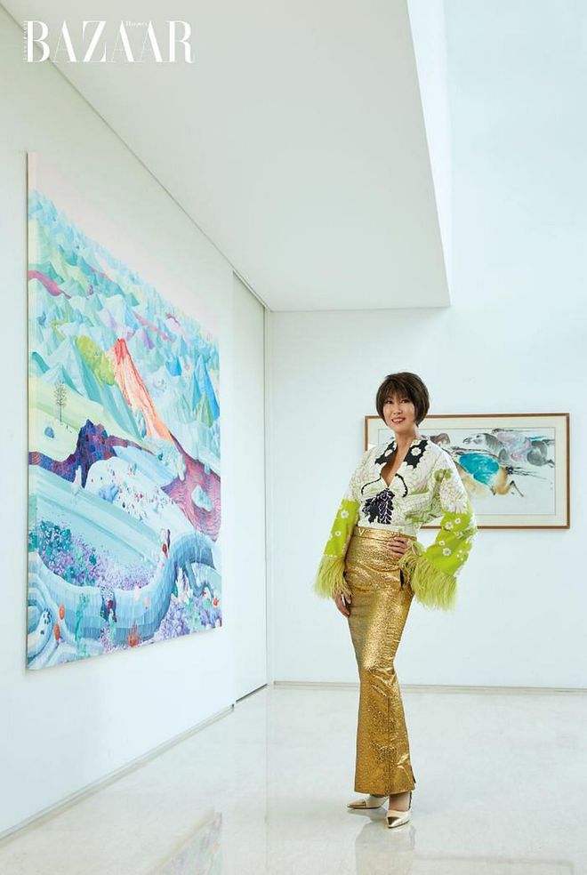Goh-Rin, an avid art collector and a patron of the arts, in a
Valentino blouse and skirt teamed with her own Chanel pumps, next to a painting she purchased at Art Stage Singapore some years back