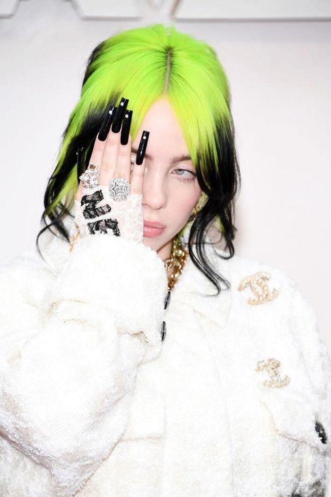 Eilish kept her neon green hair color for the Oscars, but did gently curl her face-framing layers away from her face. She also added a Chanel pin and scarf weaved through her chignon. We love her glossy black ultra-long nails with diamond details.

Photo: Kevin Mazur / Getty