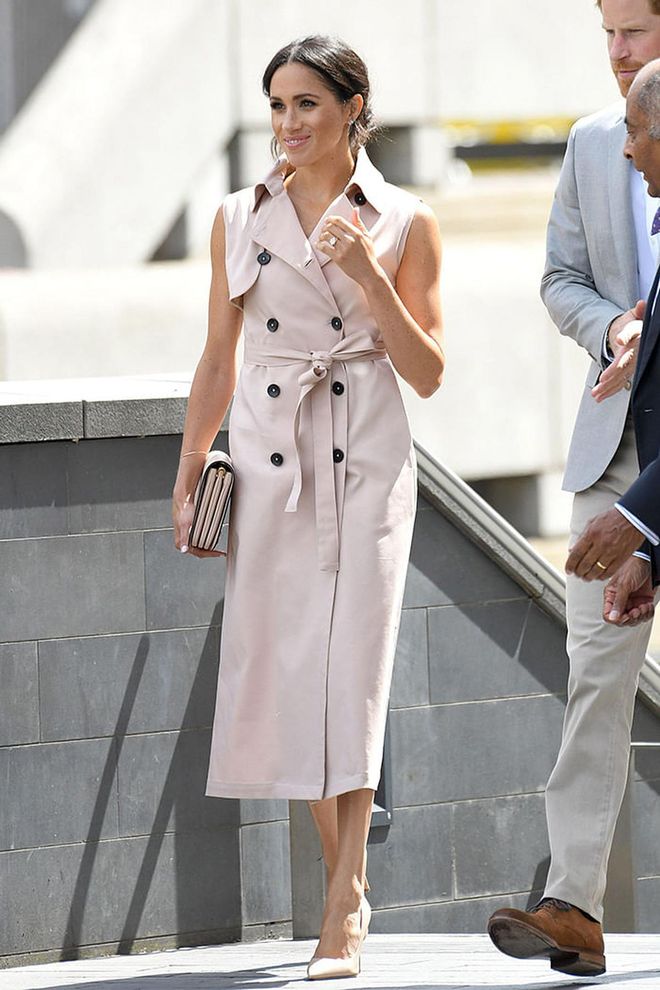 The Duchess of Sussex wore a blush pink sleeveless trench dress from Nonie paired with a matching clutch and shoes. Photo: Getty