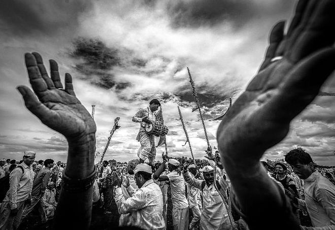 Lonkar photographs thousands of devotees at the Palkhi Festival in Pandharpur, Maharashtra, India. This moment is of a devotee standing on the shoulders of others to form a human pyramid, while playing a drum-like instrument called a Pakhavaj. Lonkar used the hands in this image to bring a sense of depth to the scene. 
