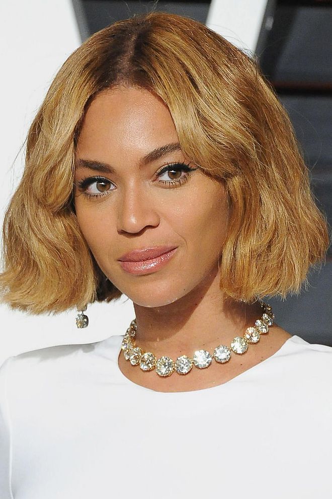 Beyoncé opts for a center part and soft waves around the face.