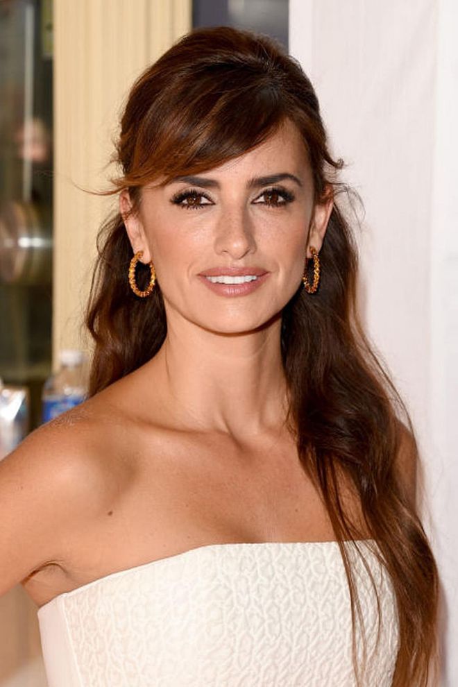 While most people opt to keep their hair away from their forehead for a half-updo, Cruz's side-bangs are a fresh take on the style that frames her face to perfection. Photo: Getty