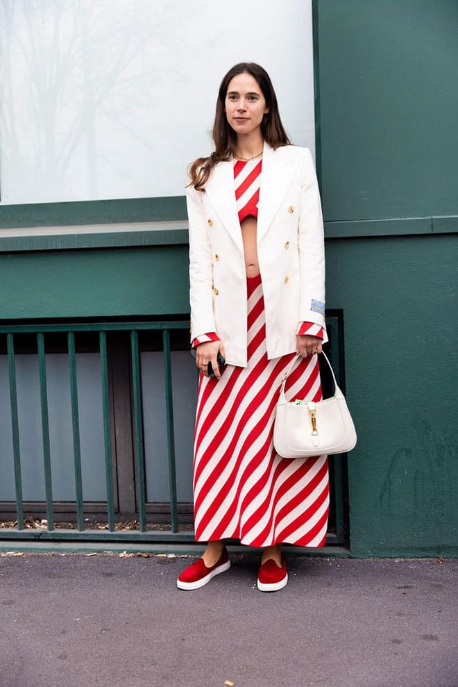 MILAN, ITALY - FEBRUARY 24: Vera Arrivabene is seen wearing a white blazer with gold buttons, wide diagonal striped skirt and crop top, white Gucci Jackie 1961 bag and red slippers outside the Gucci show during the Milan Fashion Week Womenswear Fall/Winter 2023/2024 on February 24, 2023 in Milan, Italy. (Photo by Valentina Frugiuele/Getty Images)
