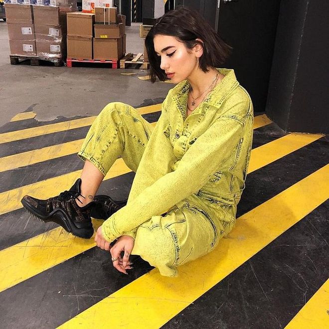 Backstage for her Stockholm show in April. Dua is glowing in this highlighter yellow Stella McCartney jumpsuit, paired with a pair of Louis Vuitton Archlight sneakers and her usual Shami necklaces.
Photo: Instagram