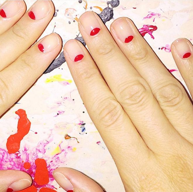 Candy apple-colored half moons bring a welcome pop of color to neutral nail beds. @mpnails