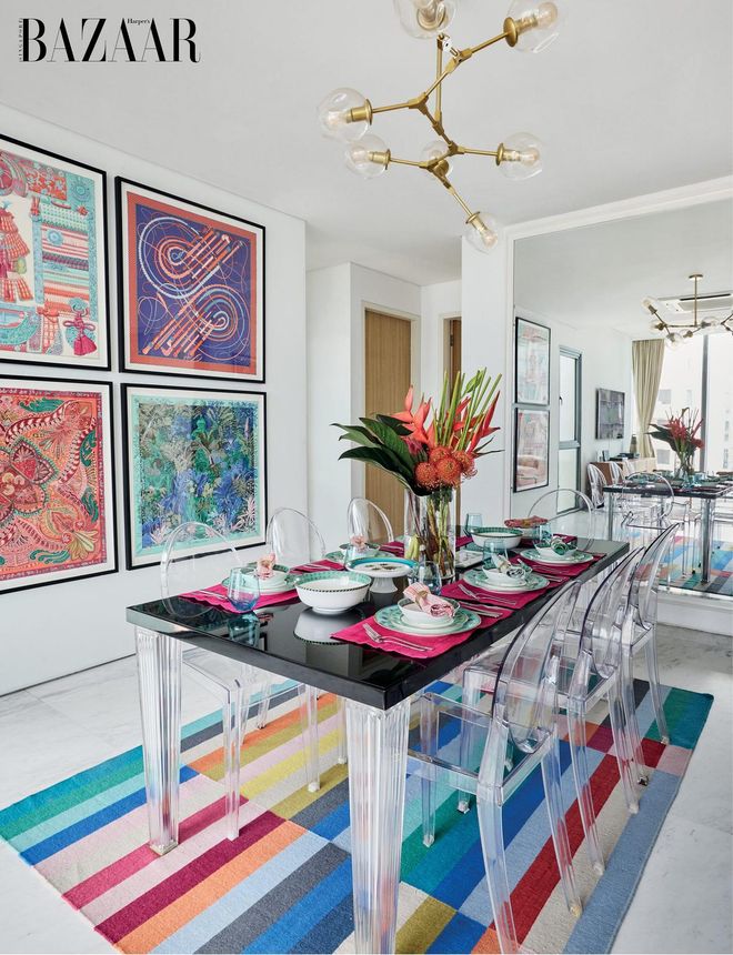 Philippe Starck’s TomTom dining table and Ghost chairs from Kartell are a balanced counterpoint to the exuberance of framed Hermès scarves on the wall.