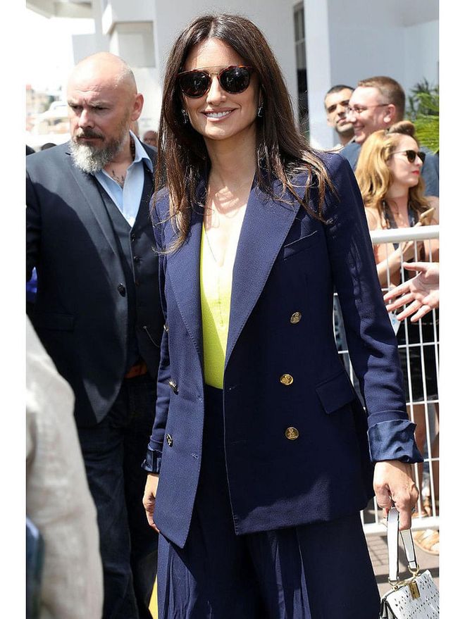8 May: Penelope Cruz arrived in the French town ahead of the film festival wearing a navy blazer, pleated skirt and a bright yellow top.

Photo: Getty