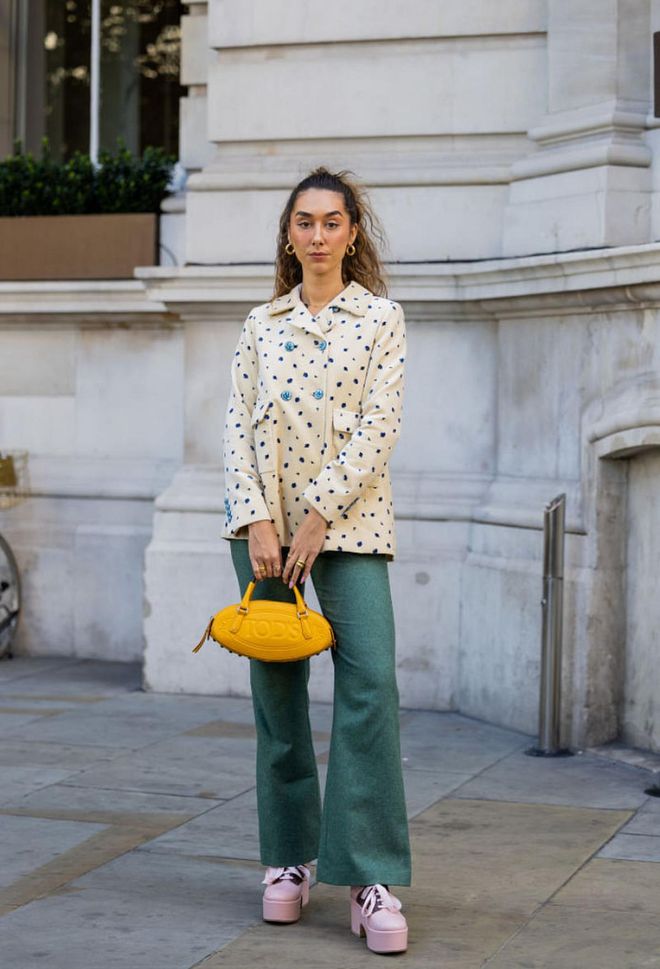 LONDON, ENGLAND - SEPTEMBER 17: Klaudia Cloud wears yellow Tods bag, beige jacket with dots print, green bag outside Paul & Joe during London Fashion Week September 2022 on September 17, 2022 in London, England. (Photo by Christian Vierig/Getty Images)