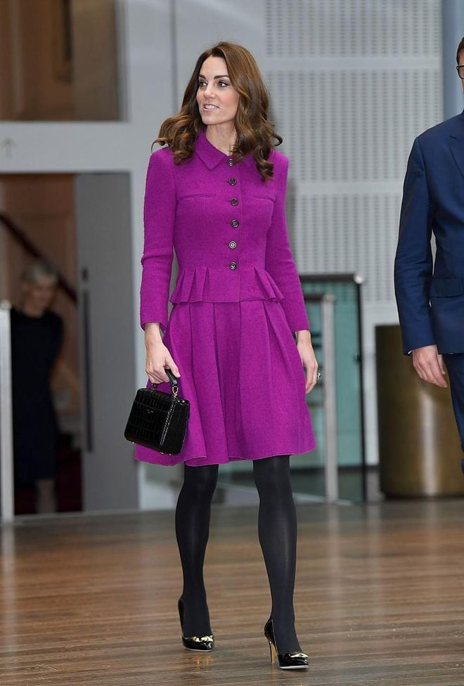 The Duchess of Cambridge brought out her vibrant violet Oscar de la Renta suit for a visit the Royal Opera House. She first wore this look in 2017. The Duchess accessorized with a black handbag by Aspinal of London and black pumps by Rupert Sanderson. 