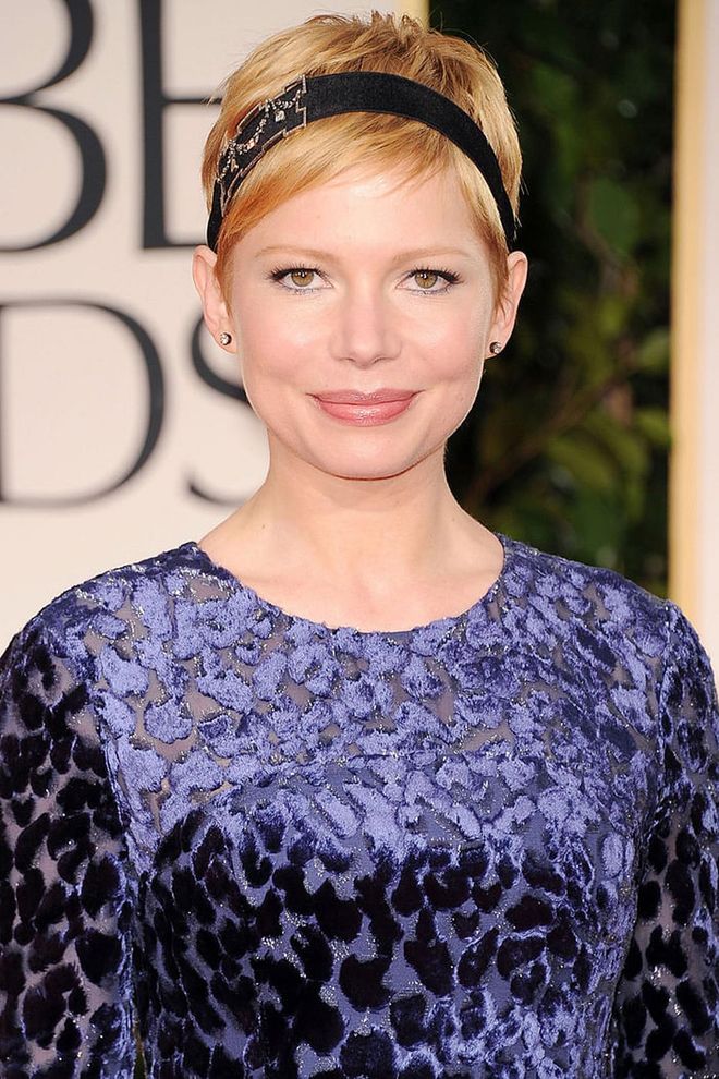 A sparkly black headband elevates Michelle Williams' signature cut to a festive beauty look fit for the occasion.
