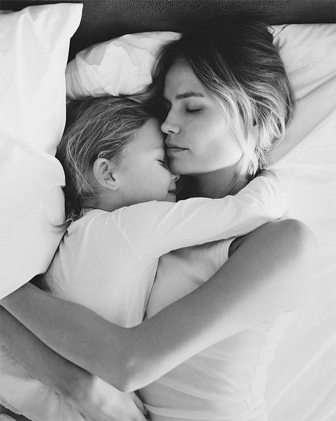 The model and her daughter Aleksandra share a sweet embrace in bed.