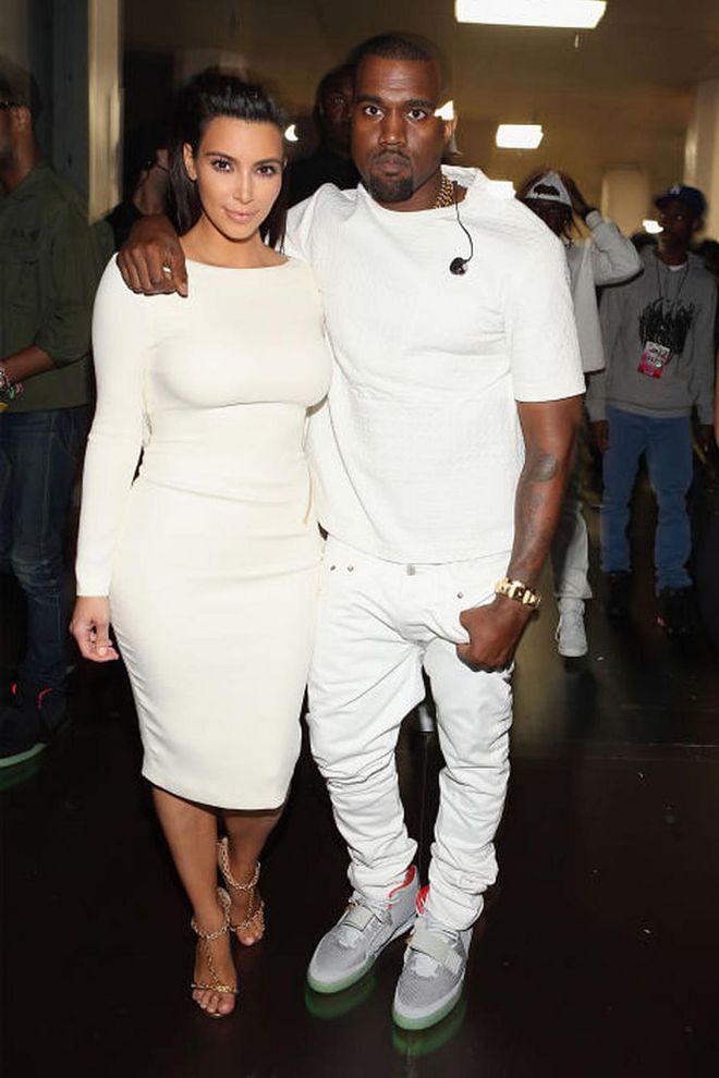 Kim in a sexy backless white Tom Ford dress, Kanye in a white T-shirt and jeans. Photo: Getty