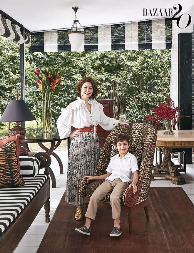 Malissa Desmazieres, in her own Duma Official blouse, Imperial skirt, accessories and Mercedes Castillo shoes, with her son Maximilian, wearing his own linen shirt and Polo Ralph Lauren trousers, at the outdoor patio of her home. The armchair is upholstered
in leopard-print fabric from Jim Thompson, while the marble dining table in the background is an antique shipped from Portugal.

(Photo: Phyllicia Wang)