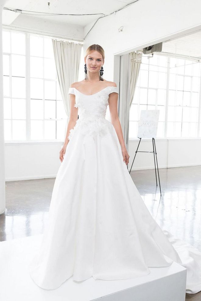 An off-the-shoulder bodice paired with a pleated skirt doesn't look any better than with a natural setting as its backdrop. Imagine this look with a flowing chapel- length lace veil. Marchesa gown, marchesa.com. 