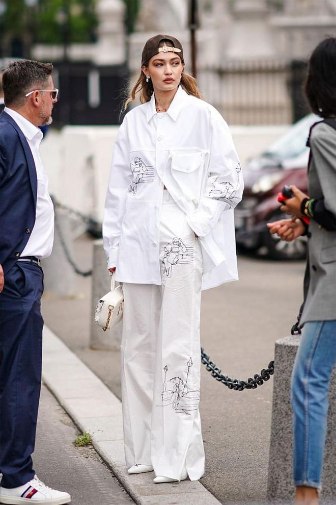 Gigi attended the Louis Vuitton Show during Paris Fashion Week Men’s SS20 wearing an all-white ensemble featuring an oversized white button-up, white wide-leg trousers and pointed white shoes. She finished off the look in a baseball cap, worn backwards.
