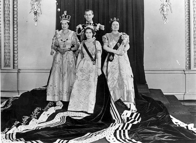 Queen Elizabeth II ascended the throne the year after her father, King George VI, passed away. Here, she's pictured on her coronation day with Prince Philip, Princess Margaret, and Elizabeth the Queen Mother, dressed in full regalia, at Buckingham Palace after the ceremony.