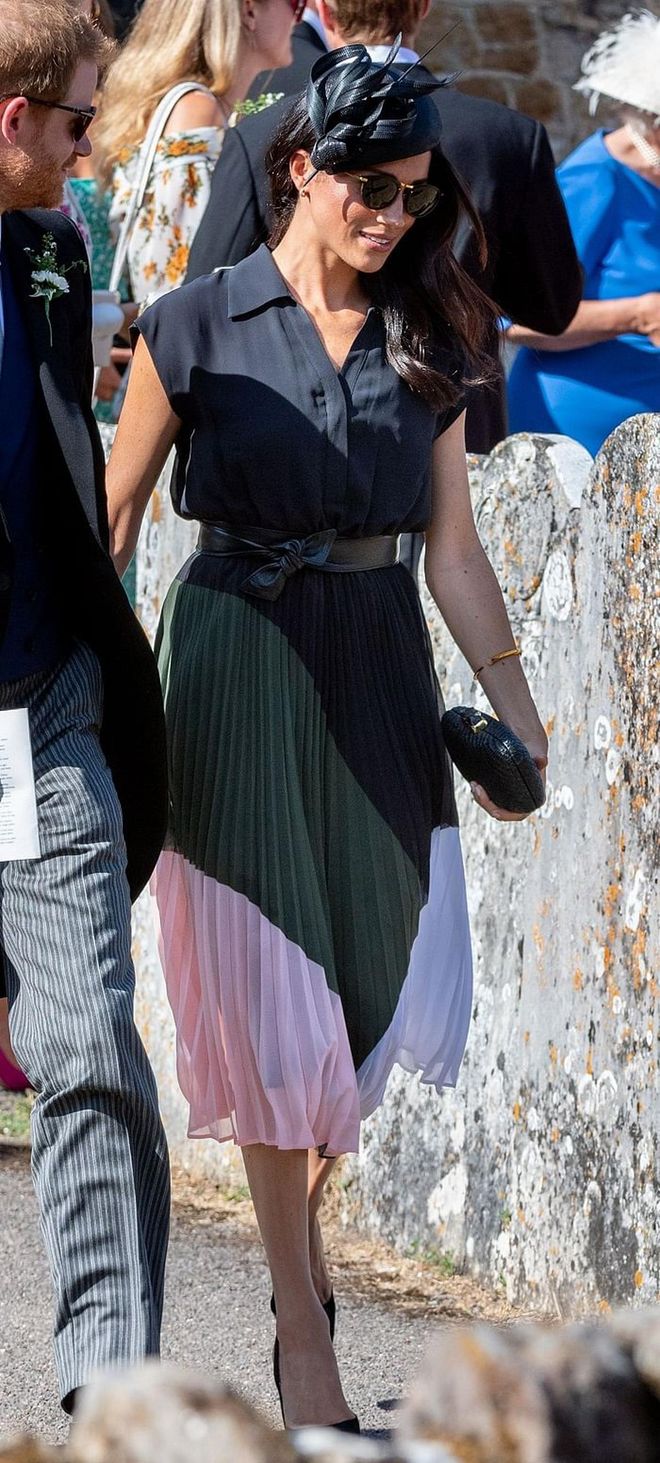 Meghan attended the wedding of Charlie van Straubenzee and Daisy Jenks in a surprisingly affordable colour-block dress from Club Monaco paired with a pair of simple black Aquazzura bow pumps. She accessorized with a Shaun Leane Gold Signature Tusk Diamond Bracelet and Philip Treacy black straw hat from SS18 Collection. Photo: Getty 
