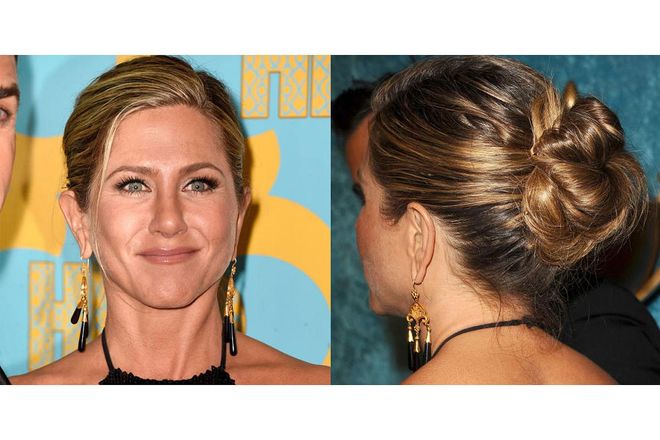 Jennifer Aniston ties up her perfectly imperfect signature strands with a deep-side part and an effortless, oversized bun. Photo: Getty