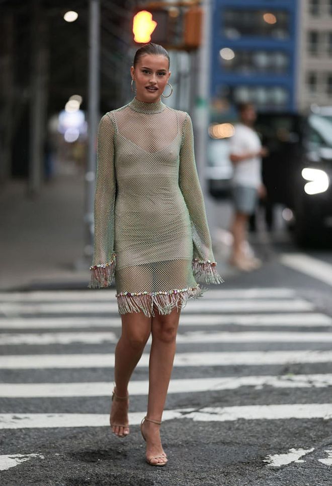 NEW YORK - SEPTEMBER 09: Lexi Wood is seen wearing large golden hoop earrings; a long-sleeved mesh mini dress with green gleam, rhinestones, colourful gemstones and fringes; beige leather strap heels outside bevor the PatBo Show on September 09, 2023 in New York City. (Photo by Jeremy Moeller/Getty Images)
