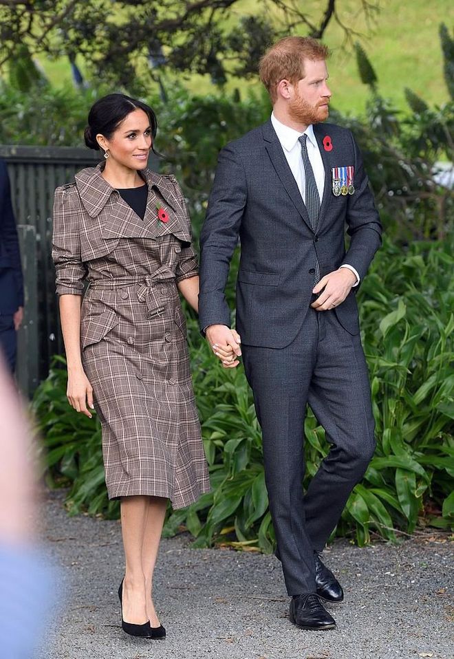Meghan was at the Pukeahu National War Memorial Park in a checked Karen Walker trench coat over a black maternity dress from ASOS, with her trusty Sarah Flint tortoise shell heels. 
