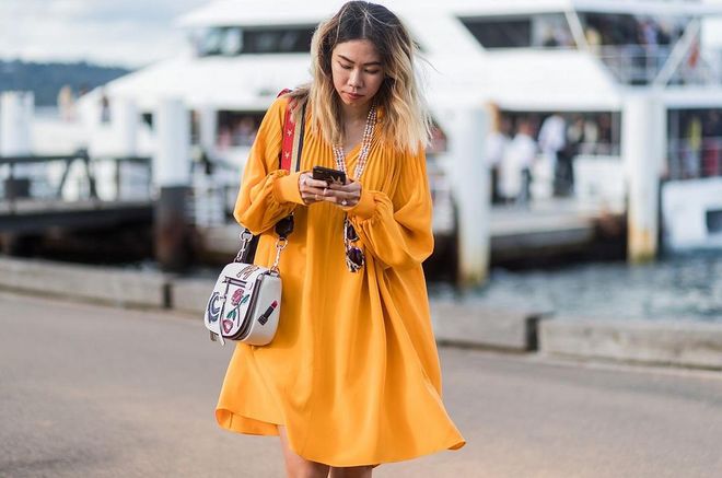 A guest wearing a yellow orange dress with long sleeves outside Dyspnea. Photo: Getty 