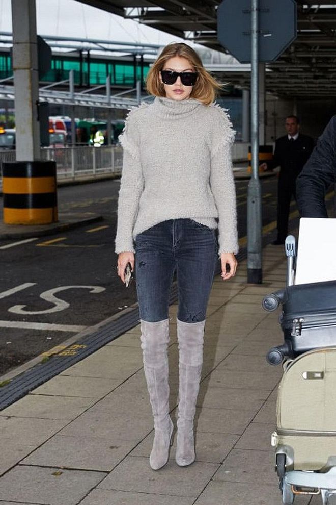 Hadid arriving at London's Heathrow Airport in a grey turtleneck, jeans and suede over-the-knee boots.
